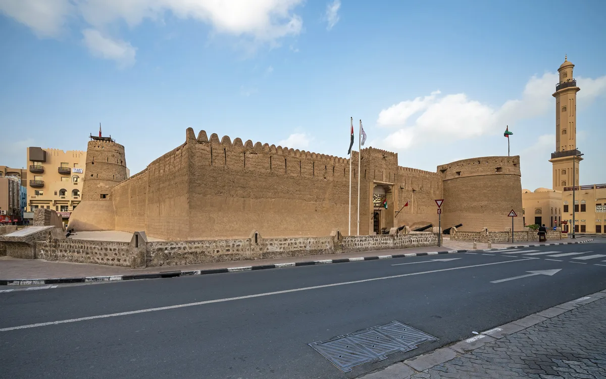 Al Fahidi Fort in Dubai - The square coral-stone fort beside Dubai Creek with round corner towers and a wind tower above the roofline