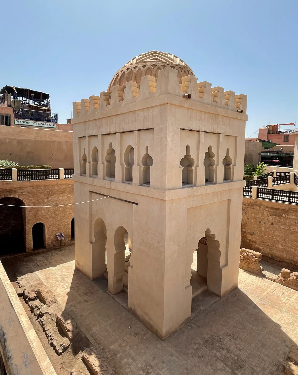 Almoravid Dome in Marrakech - A small, elaborately carved stone dome rising from a rectangular base near the Ben...