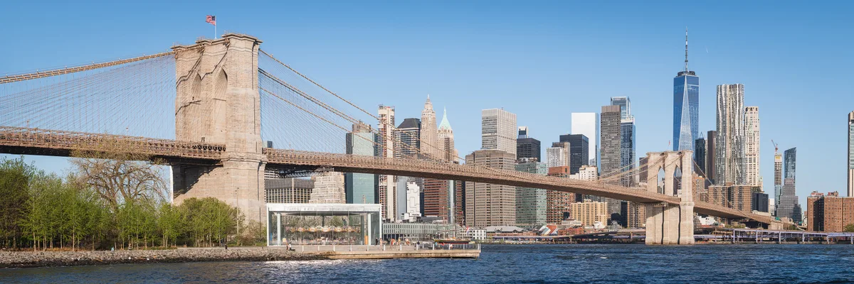 Brooklyn Bridge in New York - A suspension bridge of Gothic stone towers and steel cables spanning the East River...