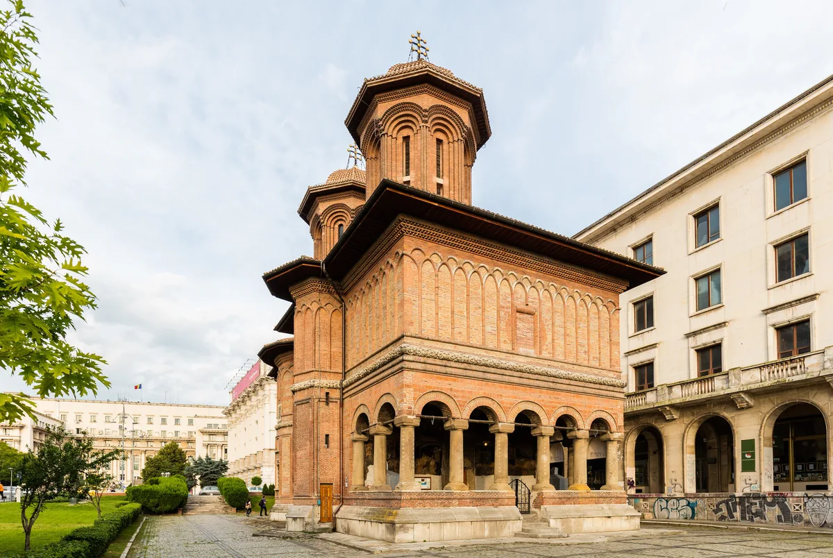 Creculescu Church in Bucharest - A compact Brancovenesc-style church with an open carved stone portico and a slender...