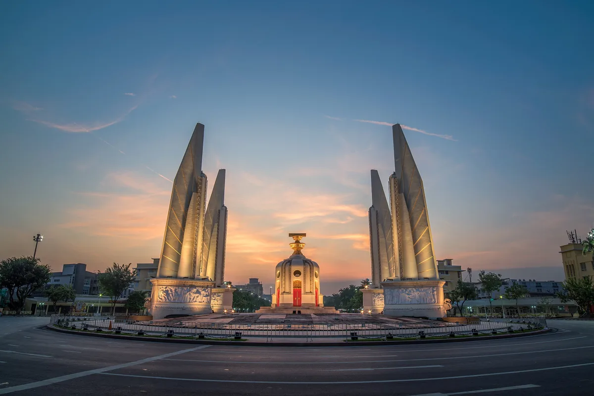 Democracy Monument in Bangkok - A central Art Deco monument with four wing-like structures framing a central spire...