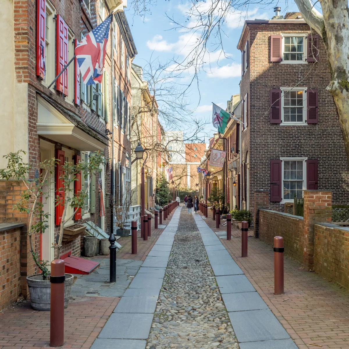 Elfreth's Alley in Philadelphia - A narrow flagstone lane of tiny brick row houses, their facades close to the sidewalk...