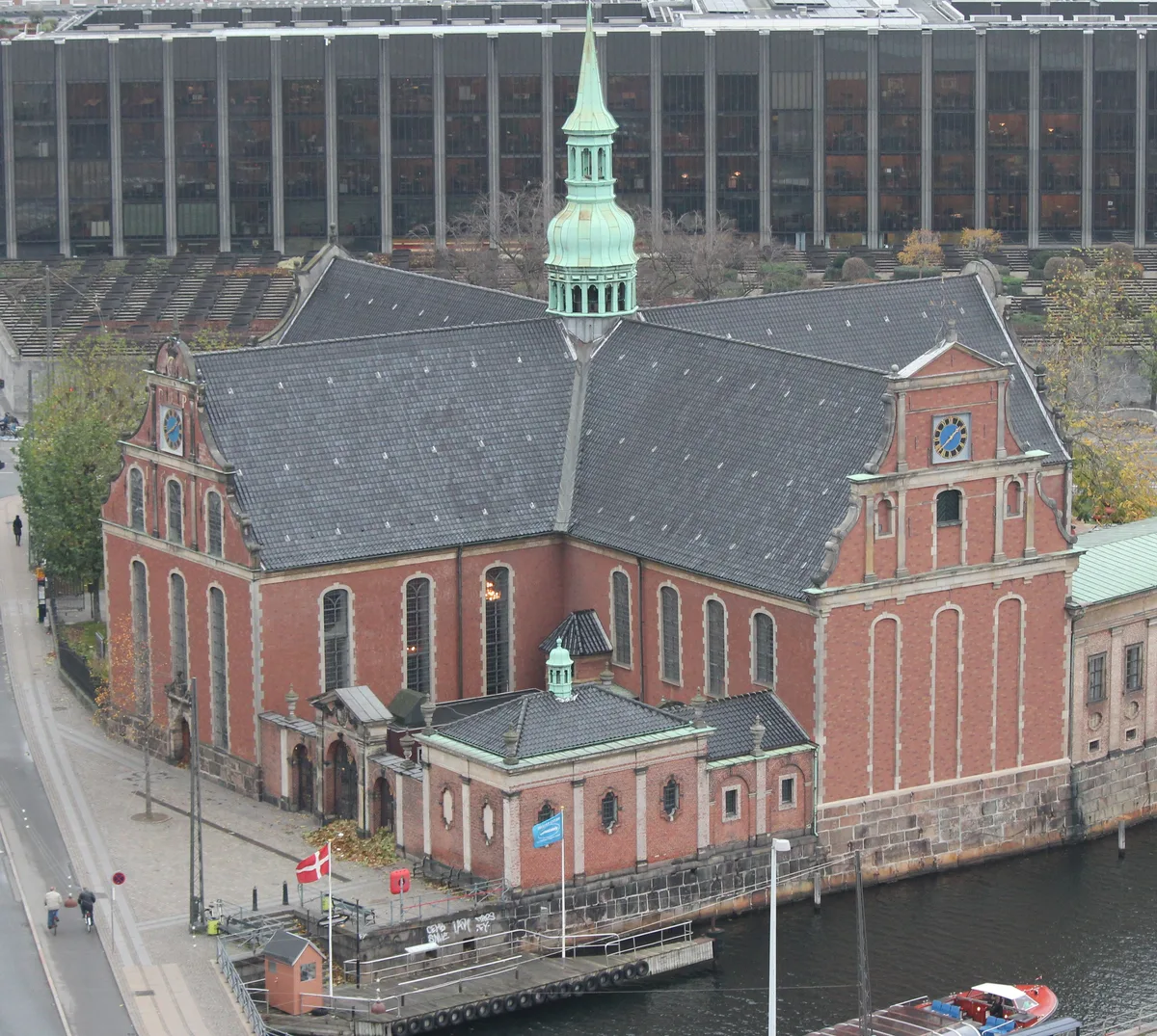 Holmen Church in Copenhagen - A white and gold church with a slim cupola tower rising over Holmens Kanal. Its facade...