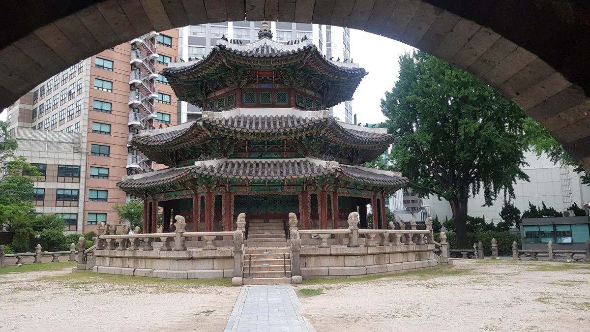 Hwangudan in Seoul - A small, stone-bordered sacred courtyard squeezed between a luxury hotel and the street, holding...