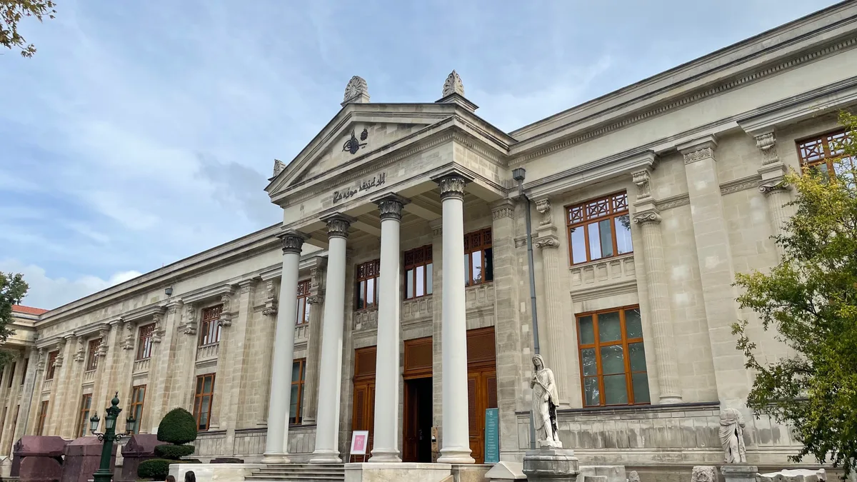 The neoclassical main facade of the Istanbul Archaeology Museums, a pale-stone colonnaded building above Gülhane Park