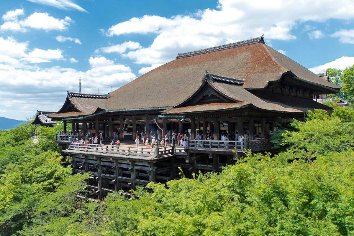 Kiyomizu-dera in Kyoto - A massive wooden temple perched on a hillside, its famous stage extending outward over a steep...