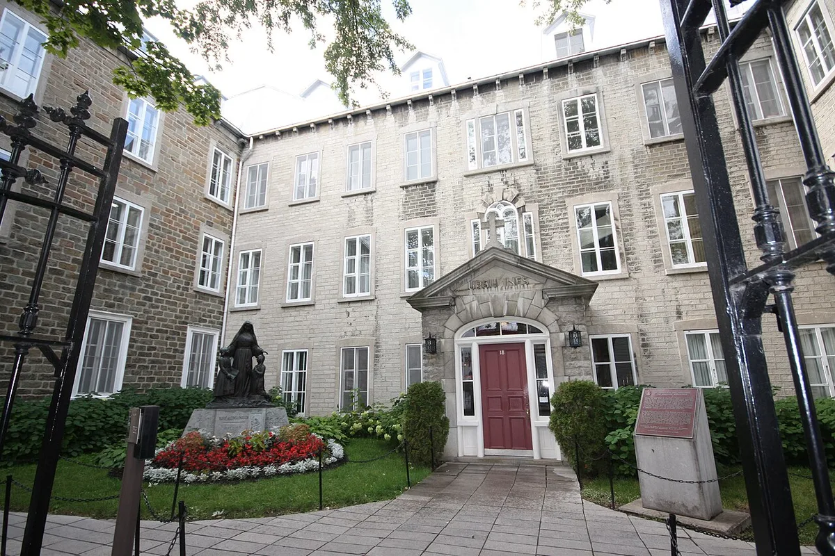 Monastère des Ursulines in Québec City - A sprawling complex of grey stone buildings behind high walls, dominated by the dome and belfry of its chapel