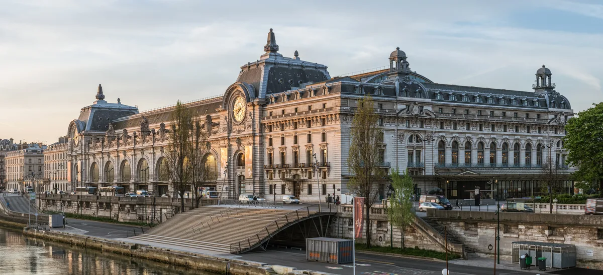 Musee d'Orsay in Paris - A grand Beaux-Arts railway station building on the Left Bank of the Seine, its monumental clock face visible on the facade