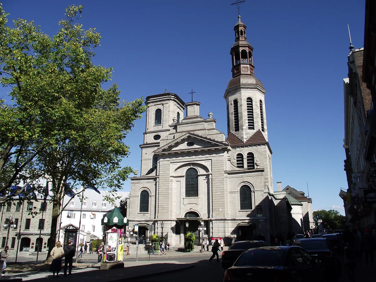Notre-Dame Basilica-Cathedral in Québec City - A wide Neoclassical cathedral with a severe stone facade and twin towers of different ages fronting the seminary garden