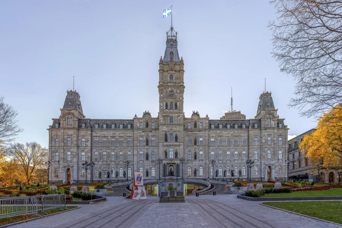 Parlement du Québec in Québec City - A long Second Empire government building of grey stone with a mansard roof, clock tower and sculpted facade