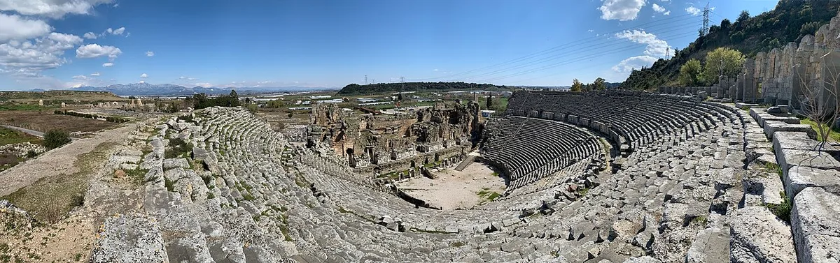 Perge Theatre in Antalya - A Roman theatre carved into the hillside, its broad cavea of seating rising in a...