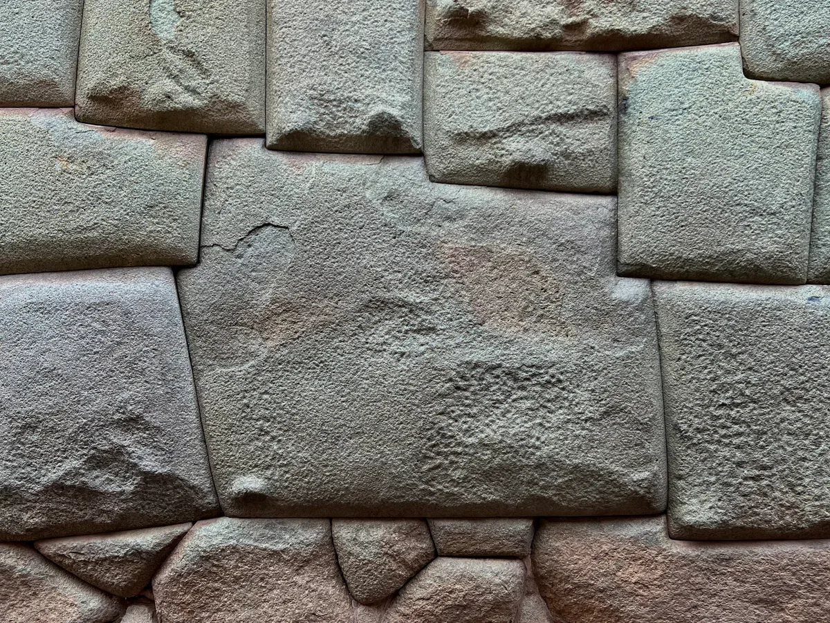 Piedra de los 12 Ángulos in Cusco - A single diorite block in a stone retaining wall on a narrow Cusco street, carved...