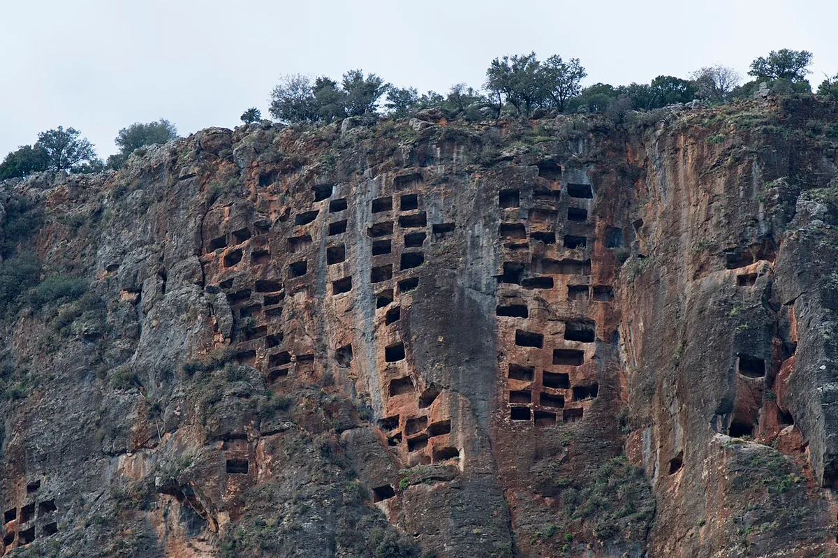 The round acropolis hill of Pinara, its cliff face honeycombed with tombs