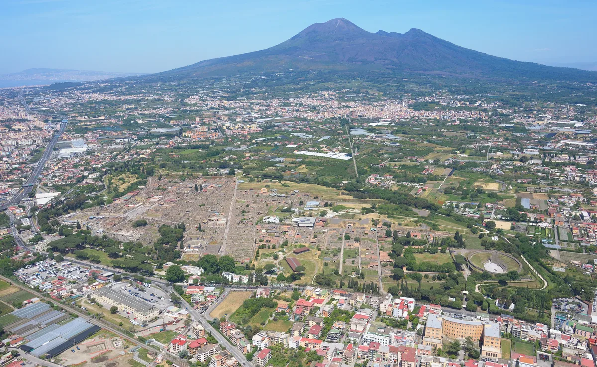 An aerial view of Pompeii's ruins beneath Mount Vesuvius
