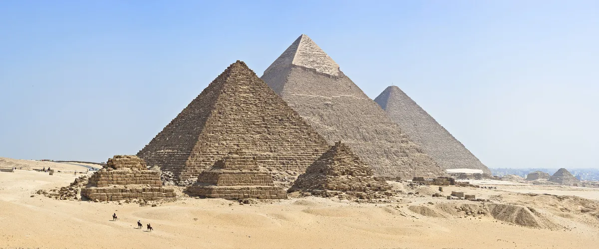 Pyramids of Giza in Cairo - Three colossal limestone pyramids rising from the Giza Plateau, with the Great Pyramid of...