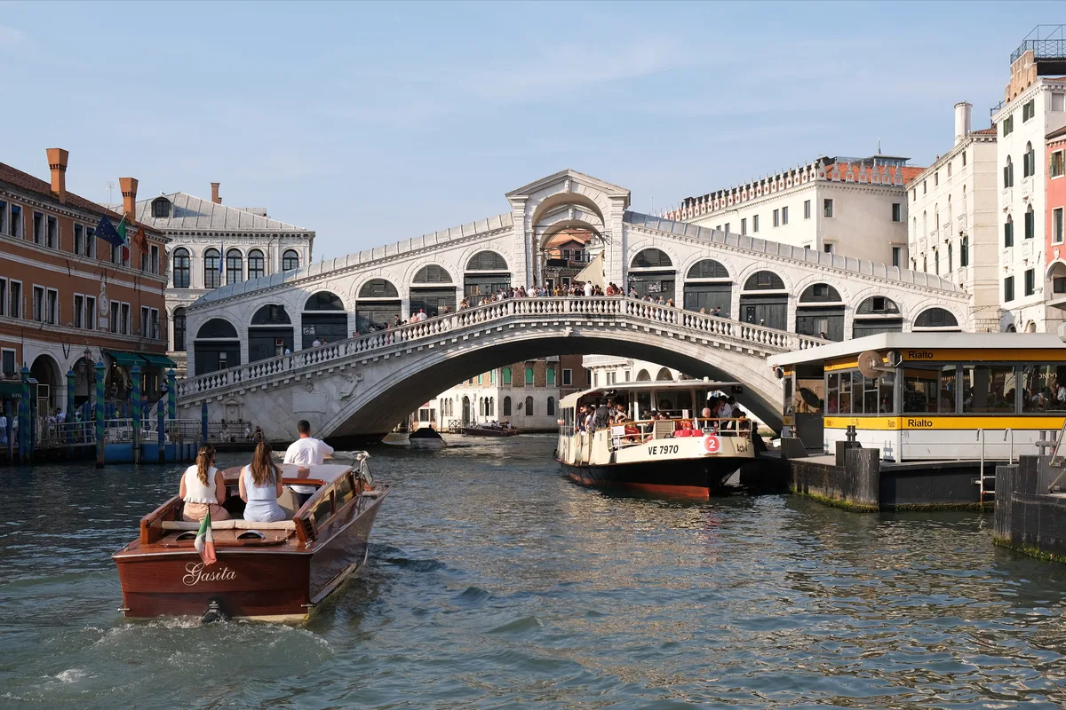 Rialto Bridge in Venice - A single great arch of white Istrian stone spans the Grand Canal, its roadway lined with two...