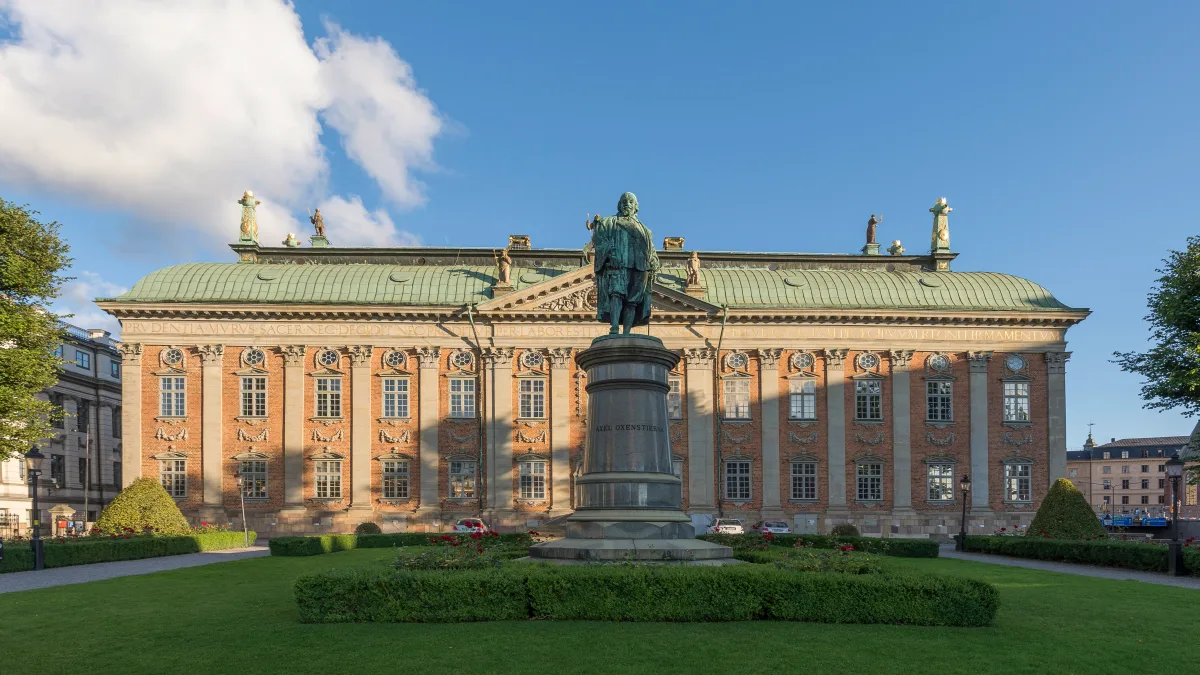 House of Nobility in Stockholm - A low, broad Baroque building with a hipped copper roof and a sculpted triangular...