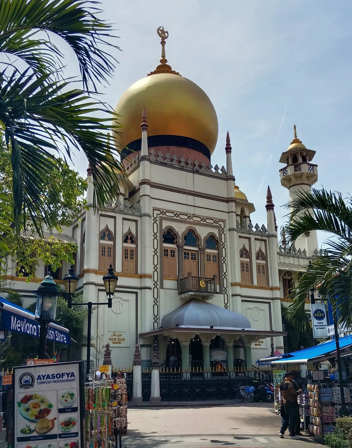 Sultan Mosque in Singapore - A striking mosque topped by a large golden onion dome, its broad white facade framed by...