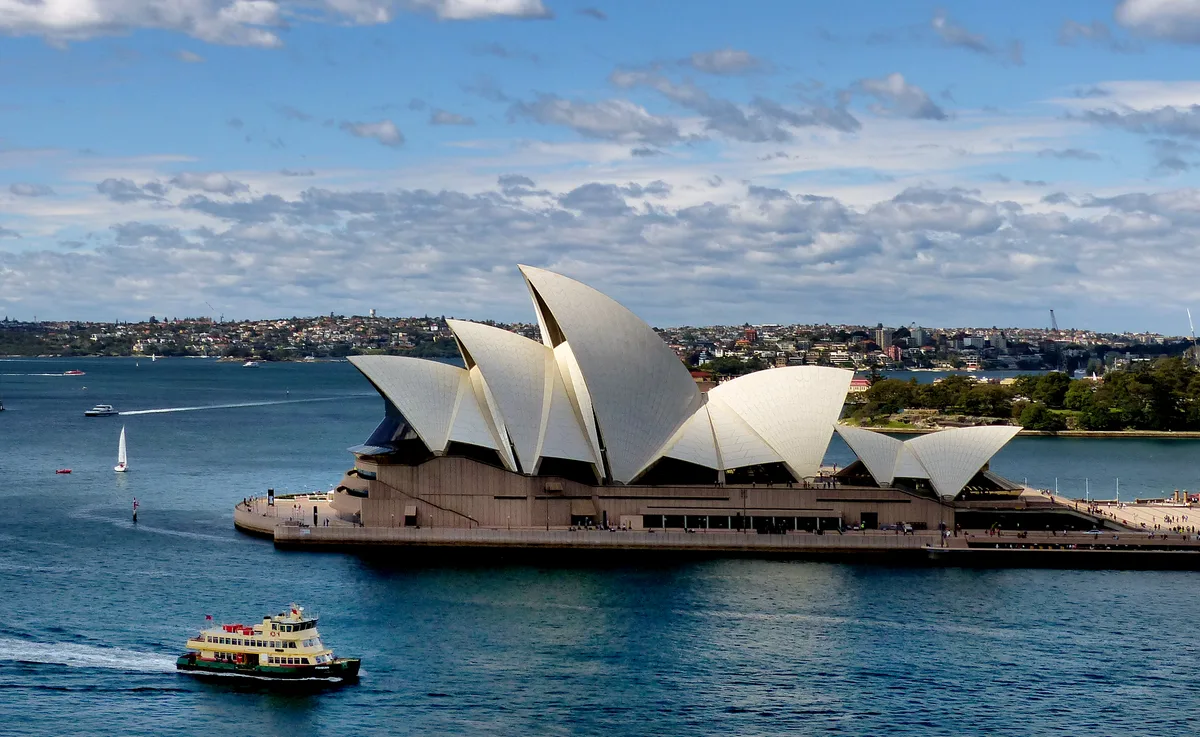 Sydney Opera House in Sydney - A soaring expressionist building with white ceramic-tiled shells rising from Bennelong...