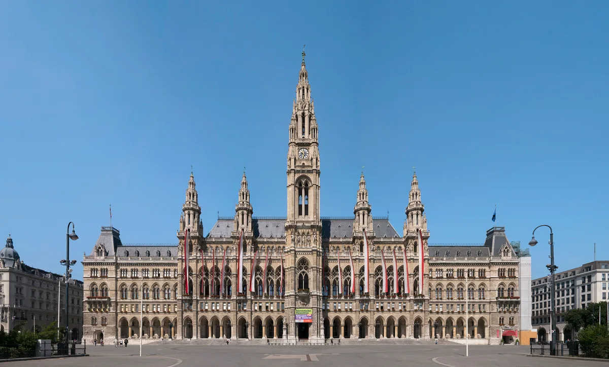 Vienna City Hall (Rathaus) in Vienna - A sprawling neo-Gothic city hall with five lace-like towers, its central tower crowned by the Rathausmann standard-bearer, fronted by the manicured Rathauspark.