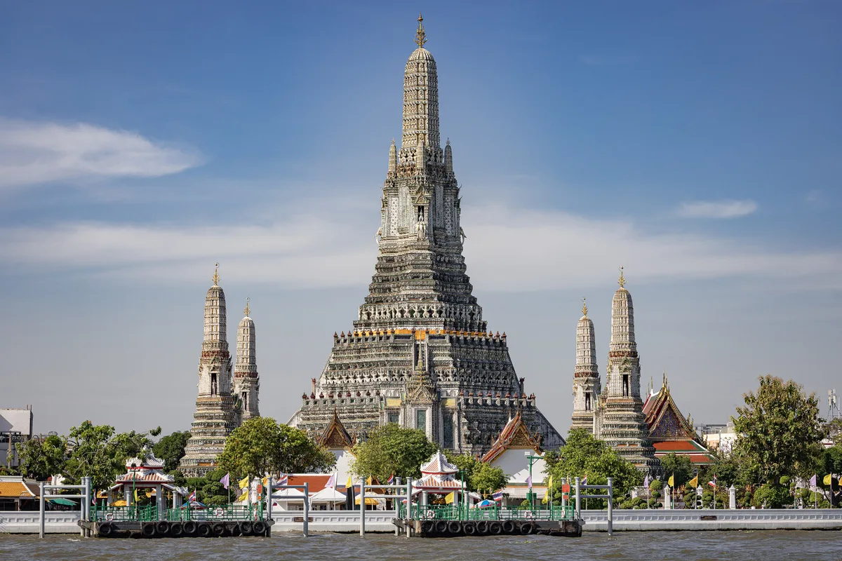Wat Arun in Bangkok - A towering 79-metre central prang (Khmer-style spire) covered in colourful porcelain fragments...