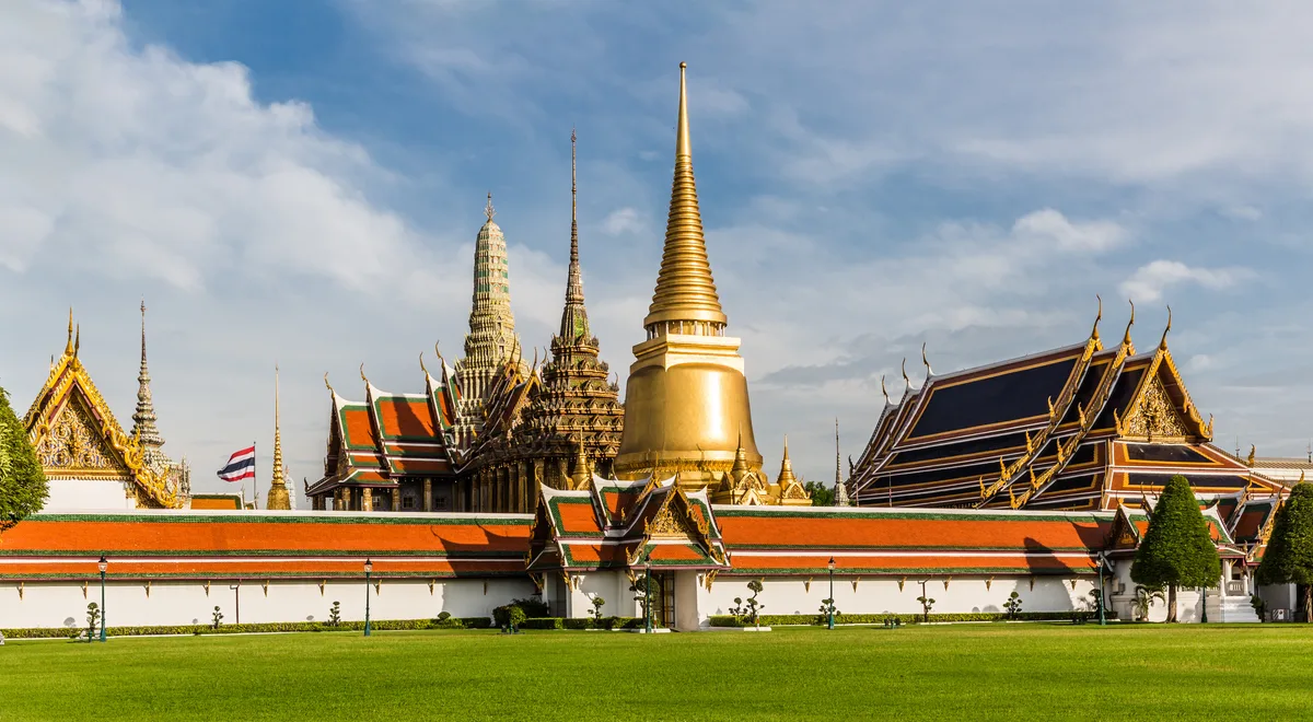 Wat Phra Kaew in Bangkok - A dazzling temple within the Grand Palace grounds with a golden chedi, ornate gable ends...