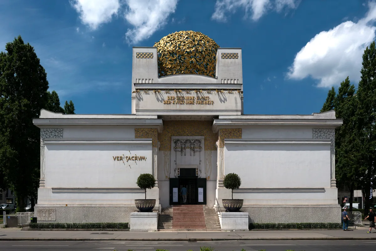Secession Building in Vienna - A stark white cube crowned by a gilded dome of laurel leaves, its facade stamped with...